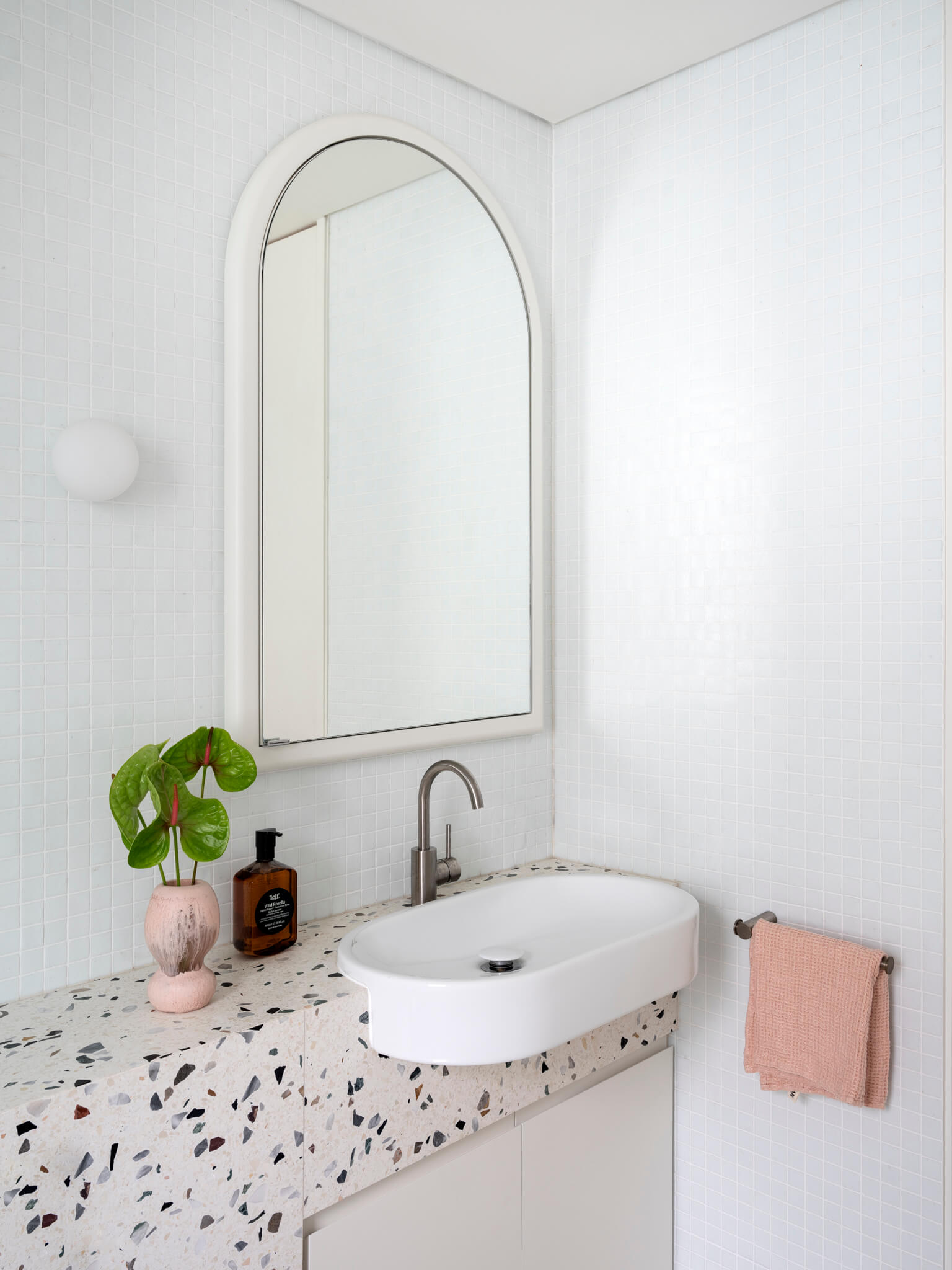 Bathroom: terrazzo countertop, white sink, arc mirror, Mosaic Square White